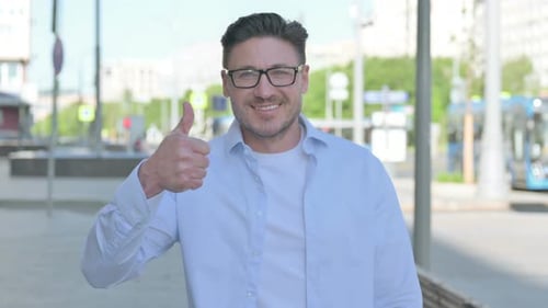 Man Gives Thumbs Up on City Sidewalk