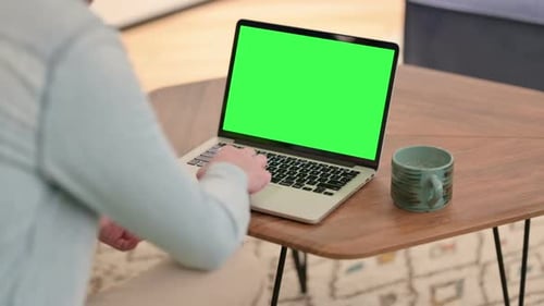 Man Working on Laptop with Green Chroma Screen