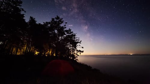 Tent on the Lake at Night Under the Starry Sky. Timelapse