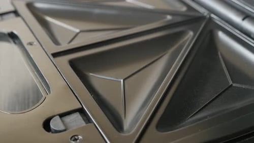 Tilting over non-sticking waffle or sandwich maker 4K 2160p 30fps UltraHD footage - Close-up of mo