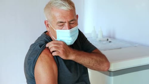Man Wearing Face Mask Receives Injection in Clinic
