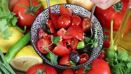 Preparing Fresh Tomato and Cucumber Salad with Forks