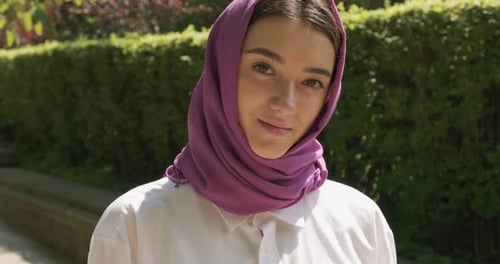 Schöne junge Frau blickt in die Kamera und trägt ein traditionelles Kopftuch. Attraktive Frau im Hijab