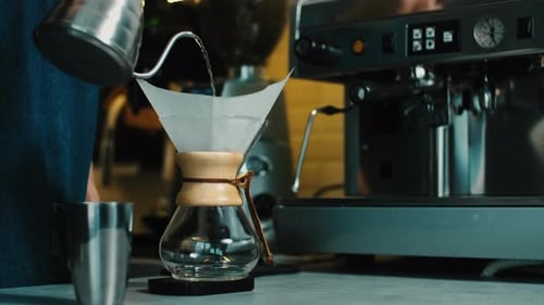 Barista making the aroma of Filter coffee for female costumer.