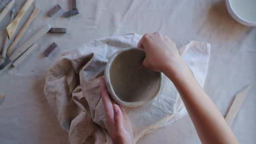 Hands Smoothing Ceramic Bowl in Pottery Studio