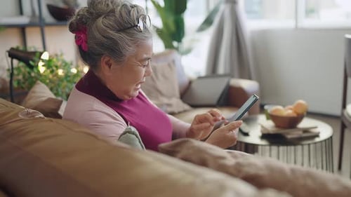 old senior asian grandmother sit casual relax hand use smartphone technology device video
