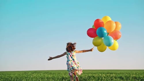 Girl Running with Balloons in a Green Field
