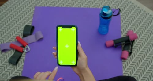 Fitness Woman Use Smartphone with Green Screen After Training at Home. Healthy Lifestyle. Stretching