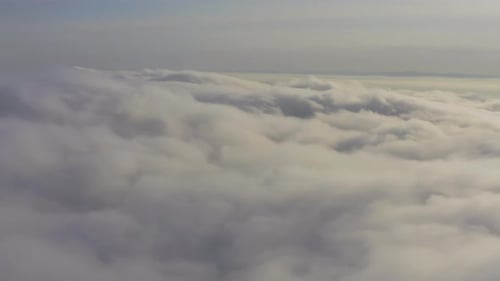 Aerial View Flying Through Cumulus Clouds at Sunset