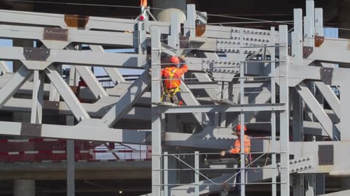 Bauherren in Uniformen überprüfen den Metallrahmen auf der Baustelle
