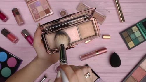Woman Working with Face Contouring Palette Powder Bronzer and Highlighter on Pink Flat Lay Cosmetics