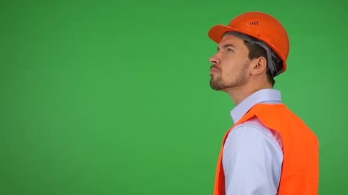 A Young Handsome Construction Worker Looks Around - Green Screen Studio