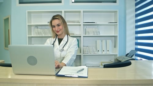 Woman Doctor Working on Laptop in Office