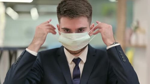 Young Adult Putting on Surgical Mask