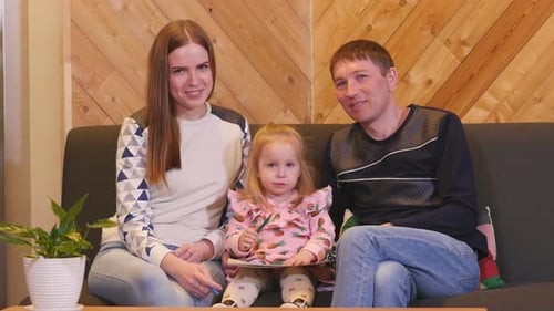 Happy Family Drawing Together on Couch Indoors
