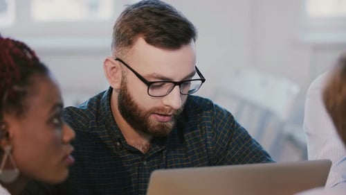 Young Successful Focused Caucasian Software Developer Working Behind Office Table with Laptop