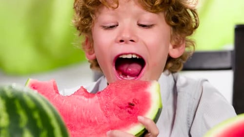 Boy Enjoying a Slice of Watermelon Indoors