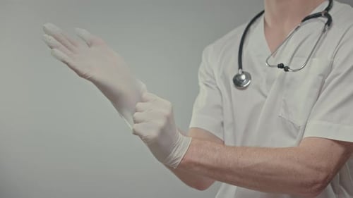 Medical Professional Putting on Gloves in Clinic