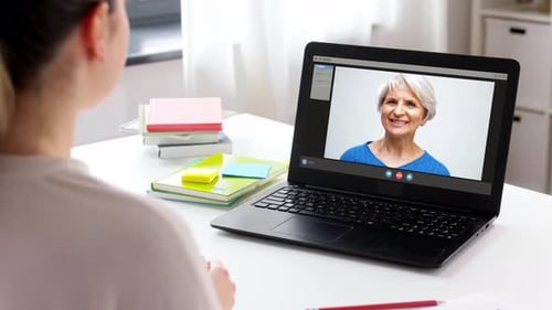 Frau mit Laptop führt Videoanruf zu Hause
