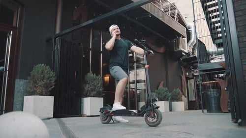 Man with Electric Scooter Talking on Phone