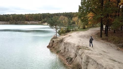Homme marchant le long du lac