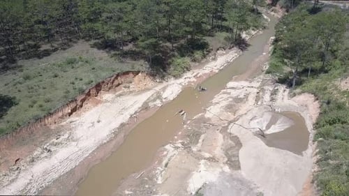 Des mineurs qualifiés travaillent sur une rivière boueuse étroite et extraient du gravier