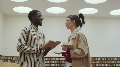 Diverse Man and Woman Talking in Library
