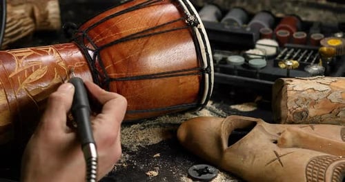 Close up male hands using power wood working tools graver