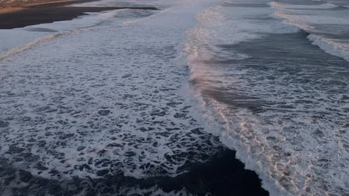 Drone Over Waves Moving Onto Beach At Sunset