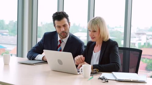 Two Business People Talk Project Strategy at Office