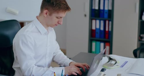 Man Typing on Keyboard Laptop Computer in Office