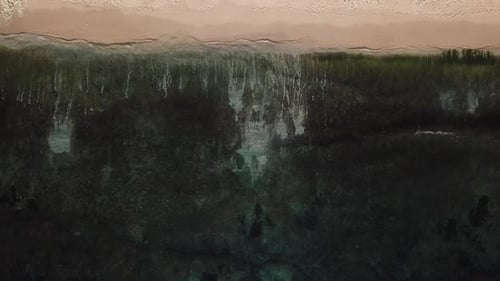 Aerial Top View of Ocean Waves Break on a Beach