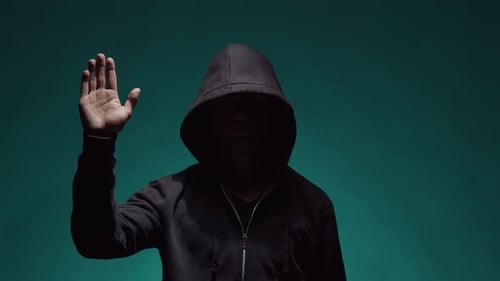Hooded Figure Raising Hand in Greeting