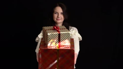 Woman Holds Stack of Wrapped Holiday Gifts