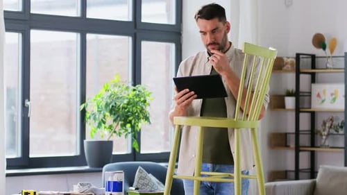 Man Using Tablet During Furniture Renovation