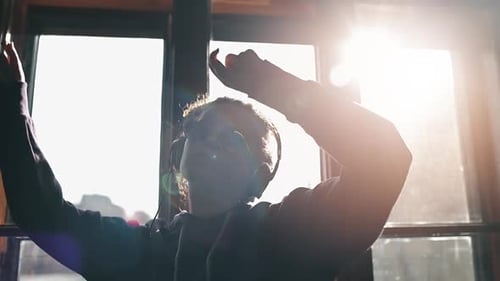 Person Dancing to Music in Bright Room