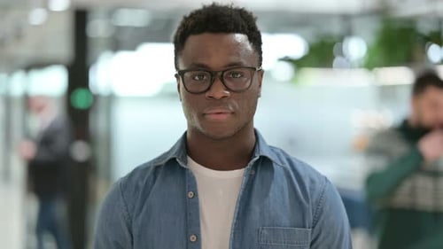 Young Man Gives OK Sign in Office