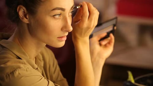 Woman Applying Makeup to Eyebrows in Home