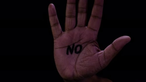 Hand Gesturing Stop with 'No' Written on Palm