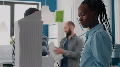 Close Up of Expert Architect Working with Woman on Building Model and Maquette in Office
