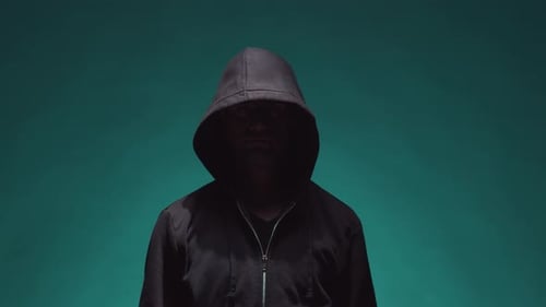 Retrato de hacker informático con capucha. Rostro oscuro oscurecido.