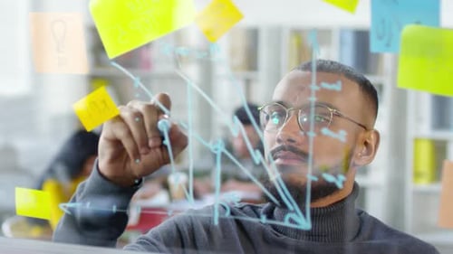 Analyste noir dessinant un graphique sur verre