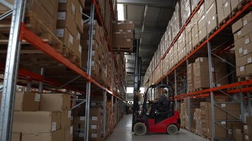 Forklift Moving Boxes in Modern Warehouse