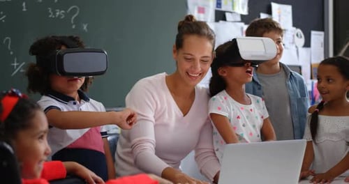 Front view of Mixed-race schoolkids using virtual reality headset with teacher and classmates i 4k