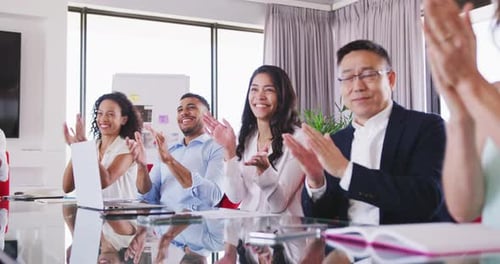 Professional businesspeople clapping together in meeting room in modern office in slow motion