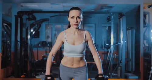 Girl Doing Exercise with Dumbbells in the Gym