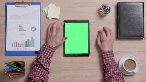 Top View of a Man Tap Multiple Times on the Left Top Corner of a Green Screen on Tablet