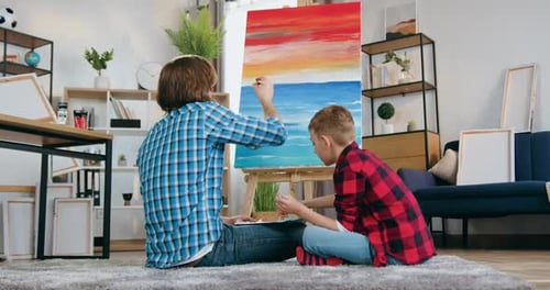 Father and Son Painting a Colorful Seascape Together