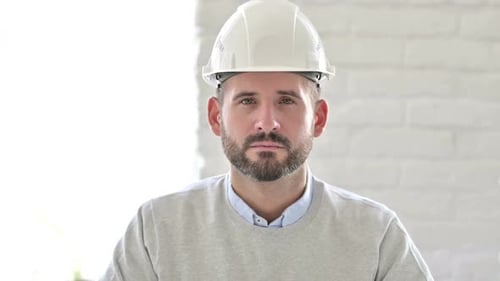Porträt eines ernsthaften jungen Ingenieurs, der in die Kamera blickt
