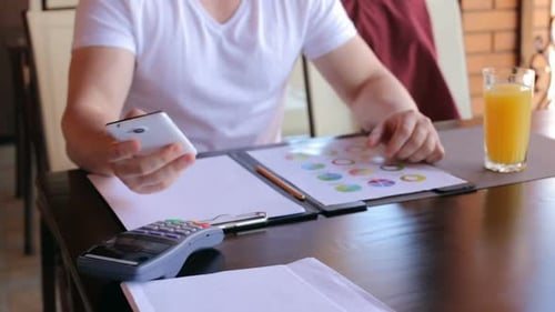 Man Analyzing Data and Technology at Table